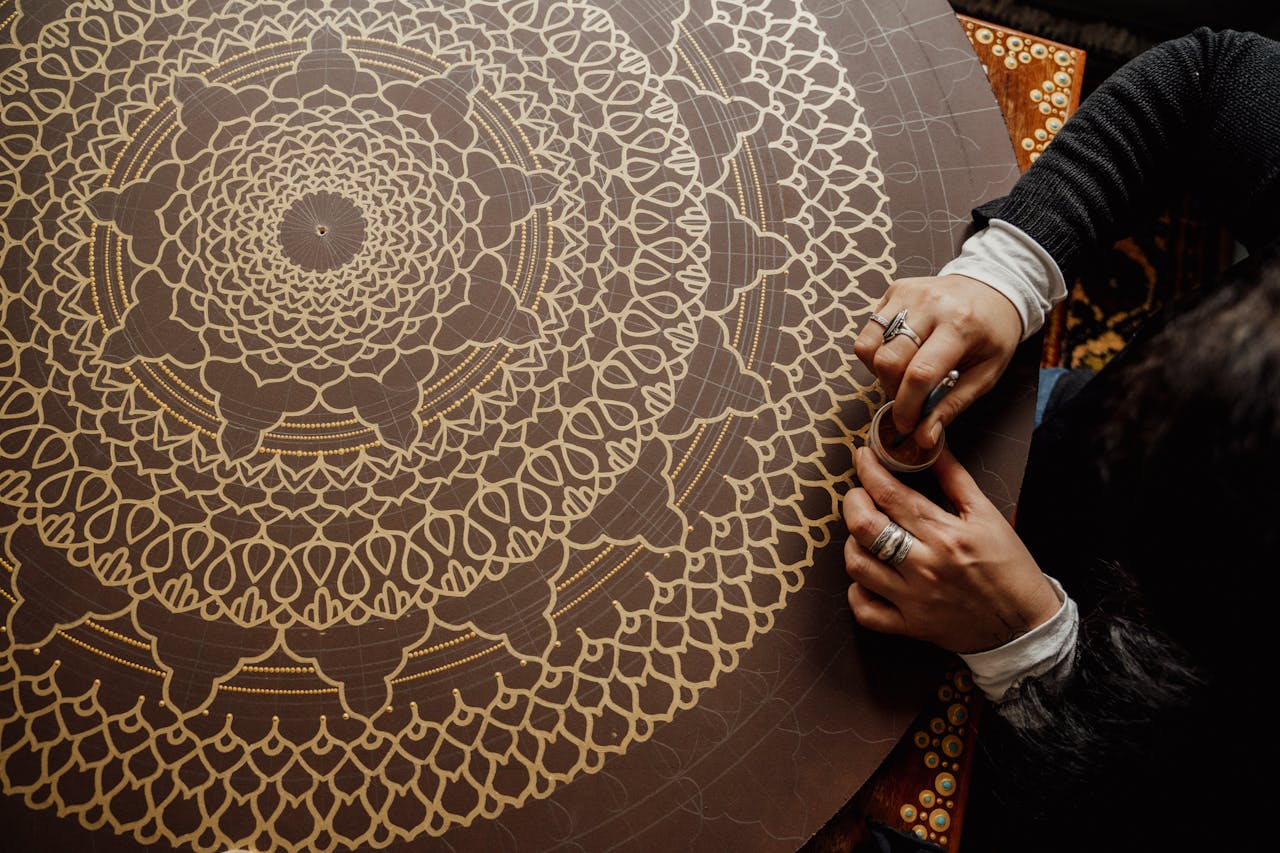 Artisan marocain réalisant un motif complexe sur un objet traditionnel.